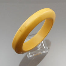 Load image into Gallery viewer, A vintage authentic bakelite plastic bangle bracelet. Opaque creamed corn yellow with streaks of brown. Simichrome tested.  Approximately 5/8&quot; x 3 3/8&quot; diameter; inside opening diameter is 2 1/2&quot;  47.1 grams  Vintage pre-owned original condition with expected scratches.
