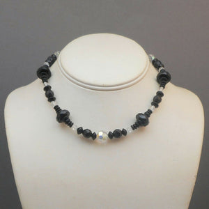 An Art Deco Era necklace of French jet (black glass) and aurora borealis beads. Choker length with opaque and iridescent round, bicone and faceted disc beads.  Beads vary from approx 5 - 12mm, necklace length is 14 1/2"  Very nice vintage pre-owned condition commensurate with age and use.  FREE Shipping to US locations