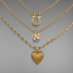 This is a charm necklace by John Wind / Maximal Art. Three chains, each with a different charm. Luck and Love themed with a horseshoe and a heart. Signed on the reverse of the horseshoe. Gold tone finish with rhinestones.  Approximately 5/8" x 21"  Excellent vintage pre-owned condition.  FREE US Shipping