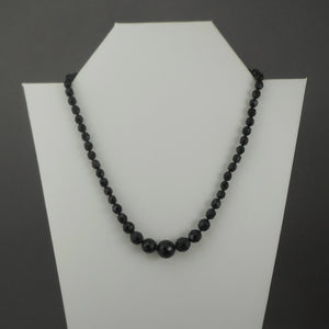 A vintage single strand necklace of French jet (black glass) beads. Collar length, adjustable, with graduated sized faceted round beads.  Approximately 17"  Vintage pre-owned condition commensurate with age and use. Some of the beads have imperfections and small nicks in the surface. FREE Shipping to US locations
