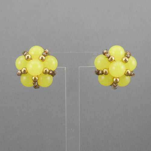 This is a circa 1950 pair of screw back earrings . Cluster style, flower design, yellow plastic and gold tone beads.  Each approximately 3/4