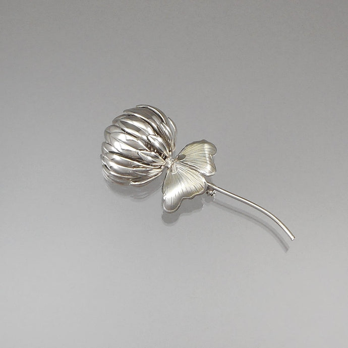 A vintage mid century modern design brooch, unsigned, circa 1960. A silver tone clover flower with a pair of leaves. Approximately 1 3/8